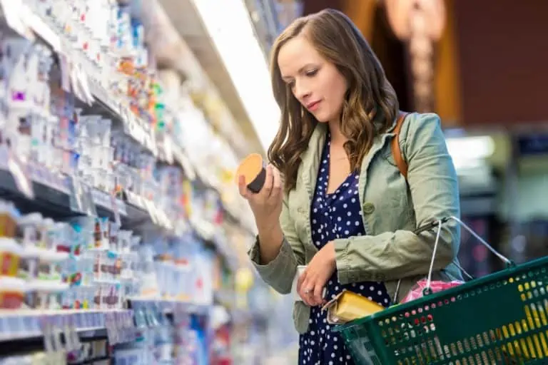 Person reading nutrition label in grocery store